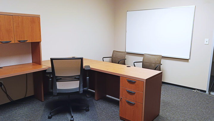 Office 1 reverse view showing the desk, visitor chairs and whiteboard