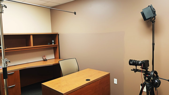 Production Room F desk with camera and lighting setup viewed from the side