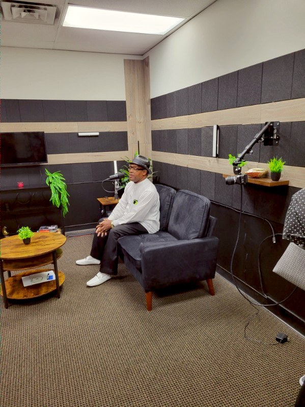 A visitor seated beside a microphone at Canis Lupus Studios