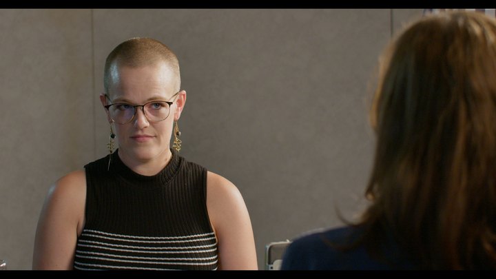 A participant in focus with another in the foreground during the Studio 1 table read