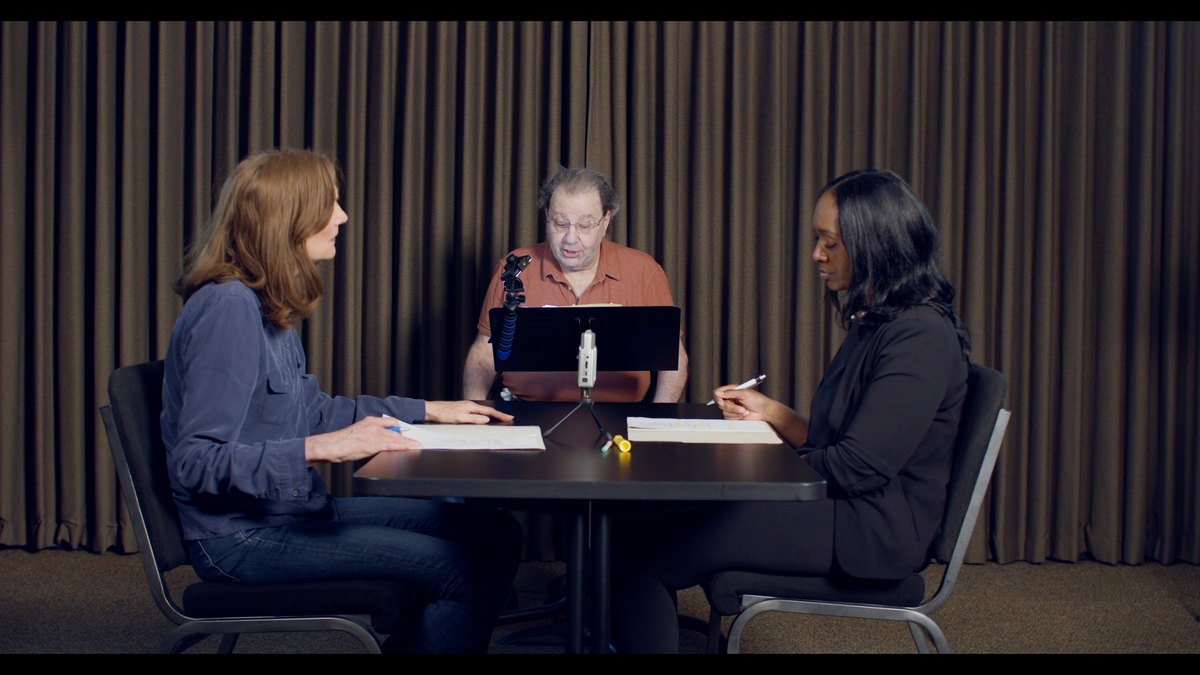 Three participants seated around a table during the Studio 1 table read